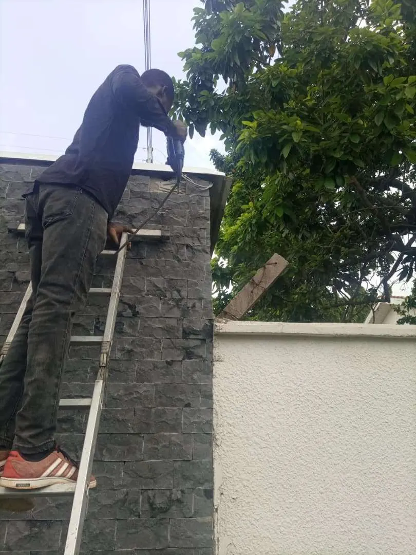 Elnux engineer drilling on a perimeter wall during a CCTV installation